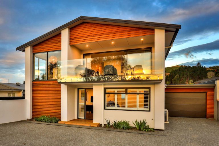 Front view of newly renovated house wooden paneling glass fenced deck